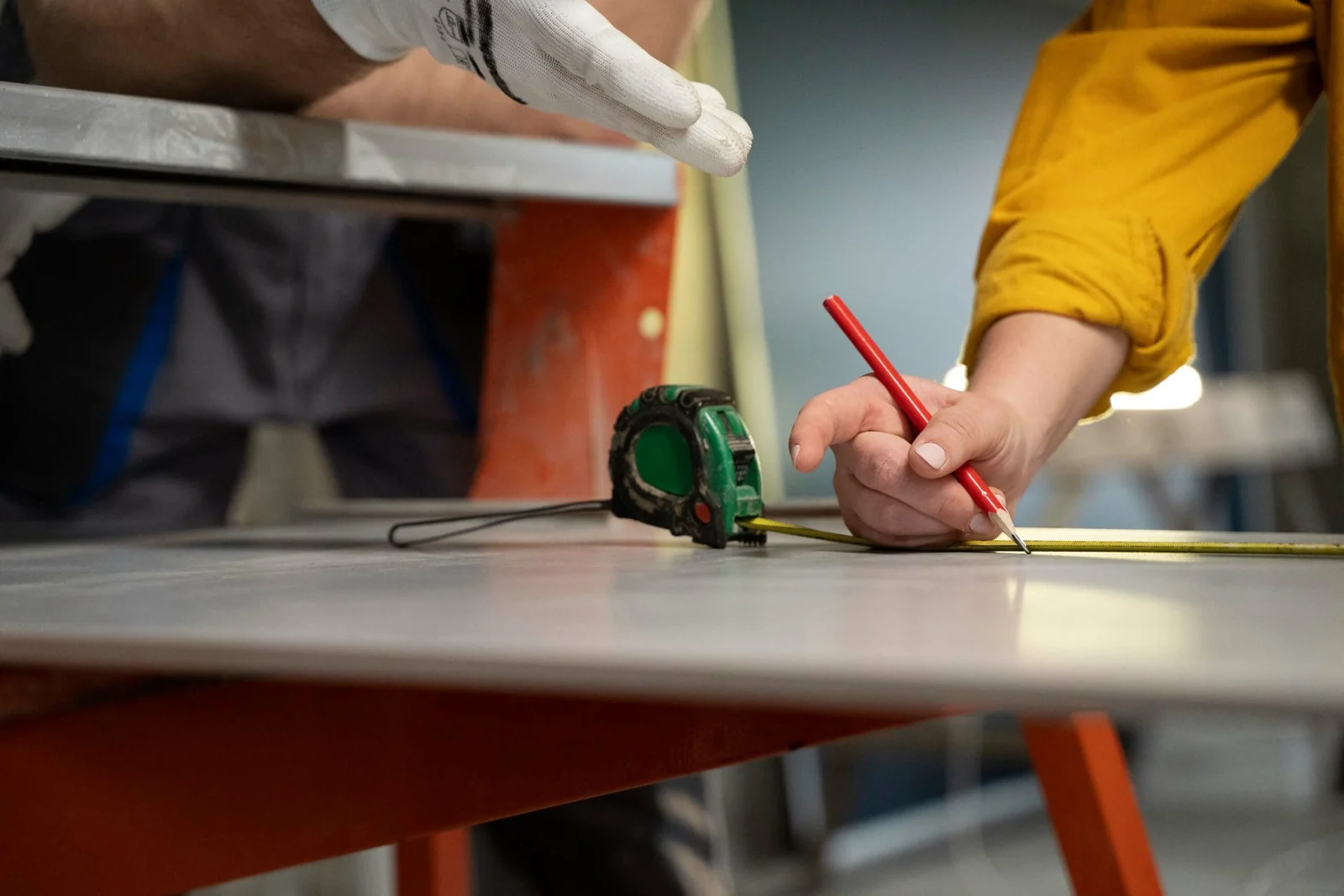 Worker measuring and marking a panel with a pencil