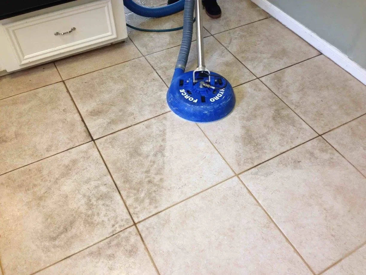 Rotary cleaning tool washing a tiled floor